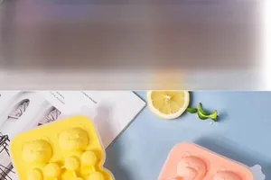 Close-up of pink and yellow silicone bear-shaped ice cube molds for food preparation