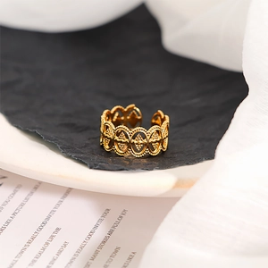 Macro detail of vintage gold open ring with ornate oval emblem and bead edges