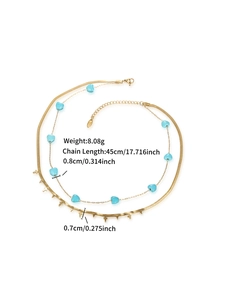 Close-up of gold double-layer necklace with turquoise hearts and cross charms