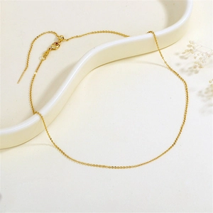 Minimalist gold link necklace with adjustable bead on an elegant ceramic display tray
