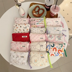Overhead view of assorted floral quilted cotton mini coin purses with zipper and woven handles