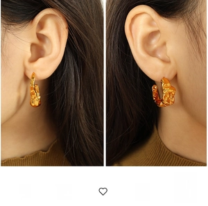 Macro view of gold 18K stainless steel lava style earrings with ripple texture