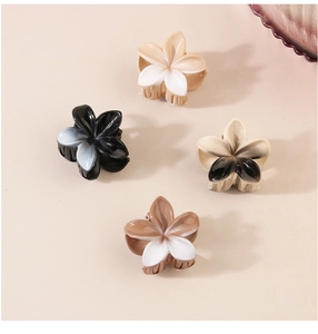 Detailansicht von vier Blumen-Haarklammern mit Farbverlauf in Creme, Schwarz und Braun