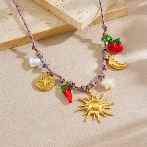 Colorful woven cord necklace with gold sun, moon pendants and charms on stone props