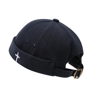 Black canvas docker hat with white cross embroidery and adjustable bronze metal buckle