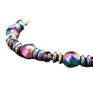 Bracelet en hématite magnétique arc-en-ciel avec perles de formes variées sur blanc