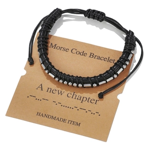 Detail of handmade leather Morse code bracelet with silver beads on a display card