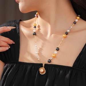 Close-up of a model wearing a multicolor pearl necklace with a gold zircon round pendant