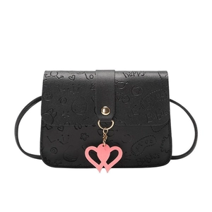 Black crossbody bag with embossed patterns and a pink heart-shaped pendant detail