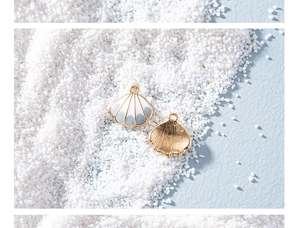 Macro shot of seashell alloy pendants with white enamel and golden sand finish