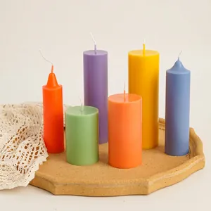 Colorful cylindrical candle set with flat and pointed tops on a wooden tray