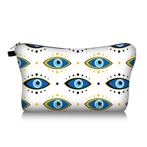 Close-up of portable makeup bag featuring vivid evil eye patterns and black zipper closure