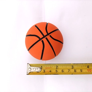 Detailed view of 6cm mini orange basketball stress ball measured with a yellow tape rule