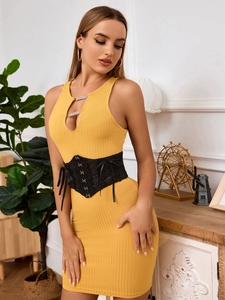 Detail of elegant black lace corset belt paired with a yellow knitted sleeveless dress