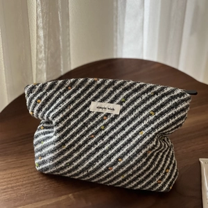 Close-up of woven polka dot cosmetic bag with texture on a wooden table surface