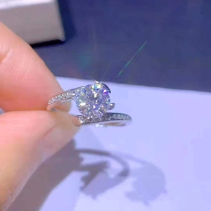 Minimalist silver four-prong 1 carat zircon open ring with side stones in hand-held shot