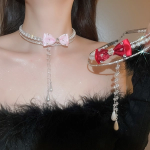 Detailed macro of rhinestone bow tassel necklace with pearls and satin ribbon finish