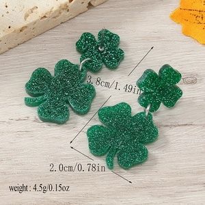 Detailed view of green glitter shamrock earrings with size measurements 3.8cm by 2.0cm