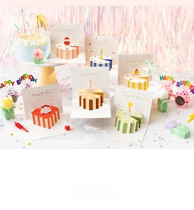 Macro shot of 3D pop-up birthday cake cards with intricate paper crafts and vibrant colors