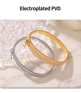 Detail of PVD plated zipper bangles in gold and silver finishes on modern acrylic display