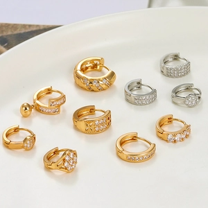 Sparkling gold and silver geometric hoop earrings with cubic zirconia in a ceramic tray