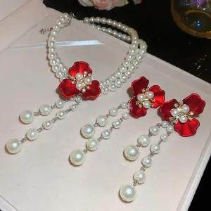 Elegant pearl and red flower jewelry set including layered necklace and tassel earrings