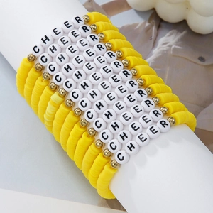 Detail of yellow Heishi clay bead bracelet with CHEER letter beads on display stand
