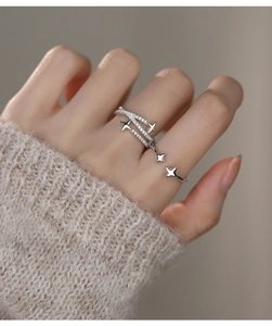 Detail of S925 silver four-pointed star rings with zircons on a model's hand