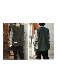 Detail of dark green water-resistant apron vest with large front pocket and drawstrings