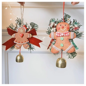 Detail of gingerbread man pendants with velvet bows, pine needles and gold bells