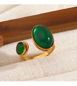 Macro view of gold-plated open ring featuring two oval translucent green gemstones