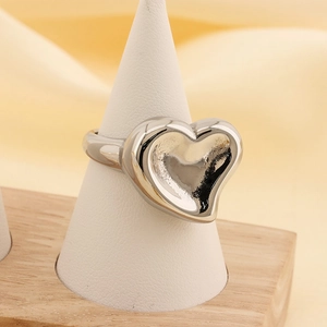 Macro view of polished silver heart ring displayed on a cone stand with mirror finish