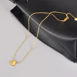 Detail of 18K gold plated stainless steel snake chain with seashell charm on leather