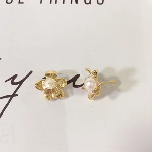 Detailed close-up of matte gold flower earrings with natural white freshwater pearls