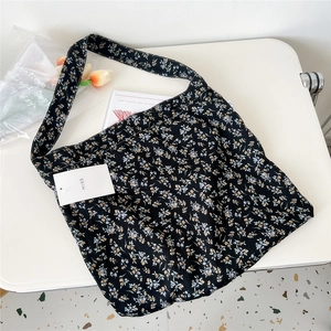 Close-up of floral canvas tote bag featuring white daisies and a MISS brand tag
