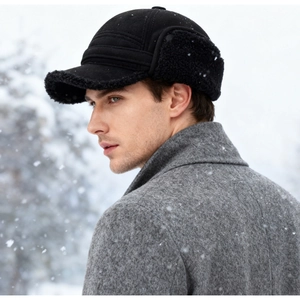 Detail of black winter trapper hat with fleece lining and ear flaps in outdoor snowy scene