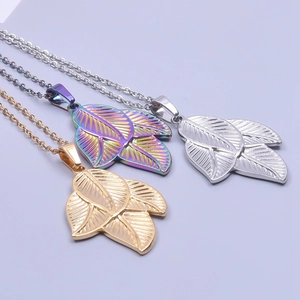 Detailed view of three-leaf pendants in gold, silver, and rainbow finishes on necklaces