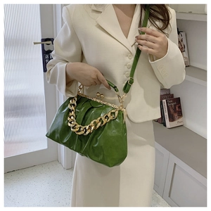 Bright green pleated cloud bag with chunky gold chain and strap shown on model