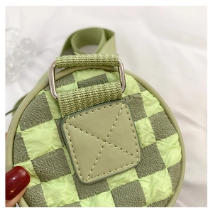 Close-up of checkerboard cylinder bag showing textured fabric and reinforced stitching