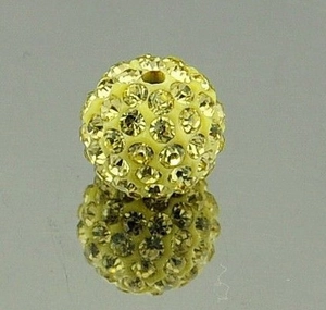 Macro shot of a yellow sparkling rhinestone clay bead with double holes for DIY jewelry