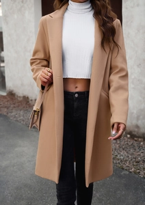 Detailed street shot of a camel wool coat with a white turtleneck crop top and black jeans