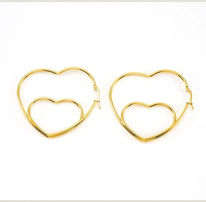 Vue détaillée des boucles d'oreilles cœur dorées doubles à la finition polie minimaliste