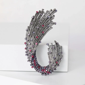 Elegant wave brooch with purple and pink rhinestones on a minimalist white platform