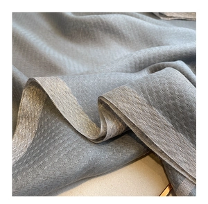 Macro shot of gray silk wool fabric with shimmering silver metallic threads texture