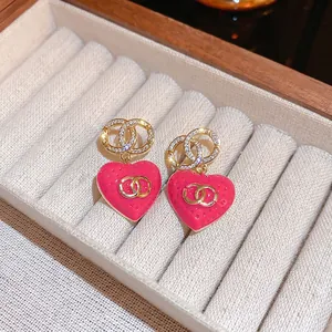 Elegant gold plated heart drop earrings with pink enamel and sparkling crystals