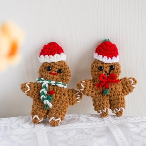 Handmade crochet gingerbread man keychains with festive Christmas hats and scarves