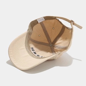 Detailed interior of 100% cotton beige baseball cap showing seams and inner band