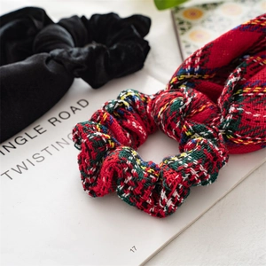 Detail of black velvet and red-green plaid Christmas scrunchies on a vintage book