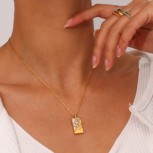 Close-up of celestial tarot pendant featuring sun and star charms on gold chain