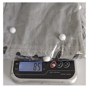 Detailed view of the 85g lightweight Christmas plush sock gift bag being weighed on a scale